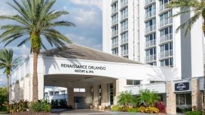 hotel with palm trees on the side and restaurant